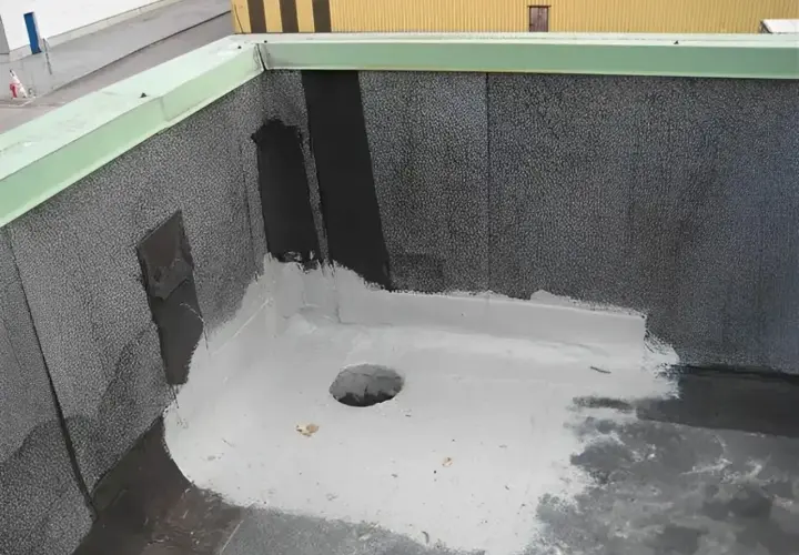 Nowy dach z papy z uszczelnieniem z elastomeru. Widać otwór odpływowy i zieloną attykę.