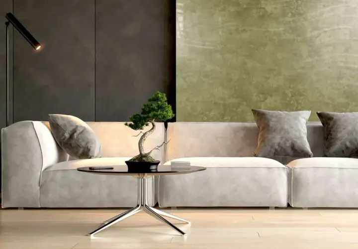 Nowoczesny salon z sofą, stolikiem i bonsai. Ściana za sofą pokryta jest efektowną **glinką wenecką** w odcieniach zieleni i grafitu.