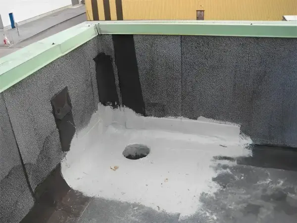Nowy dach z papy z uszczelnieniem z elastomeru. Widać otwór odpływowy i zieloną attykę.
